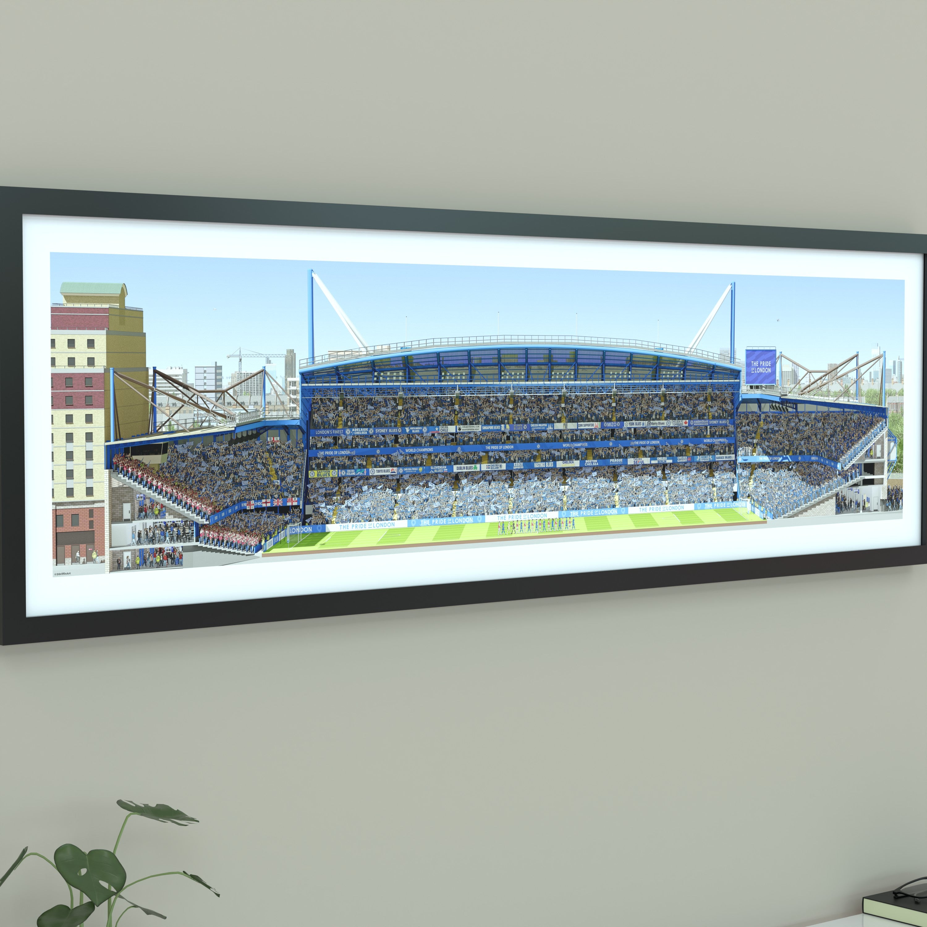 A framed panoramic print of a Chelsea’s Stamford Bridge stadium, displayed on a light gray wall.