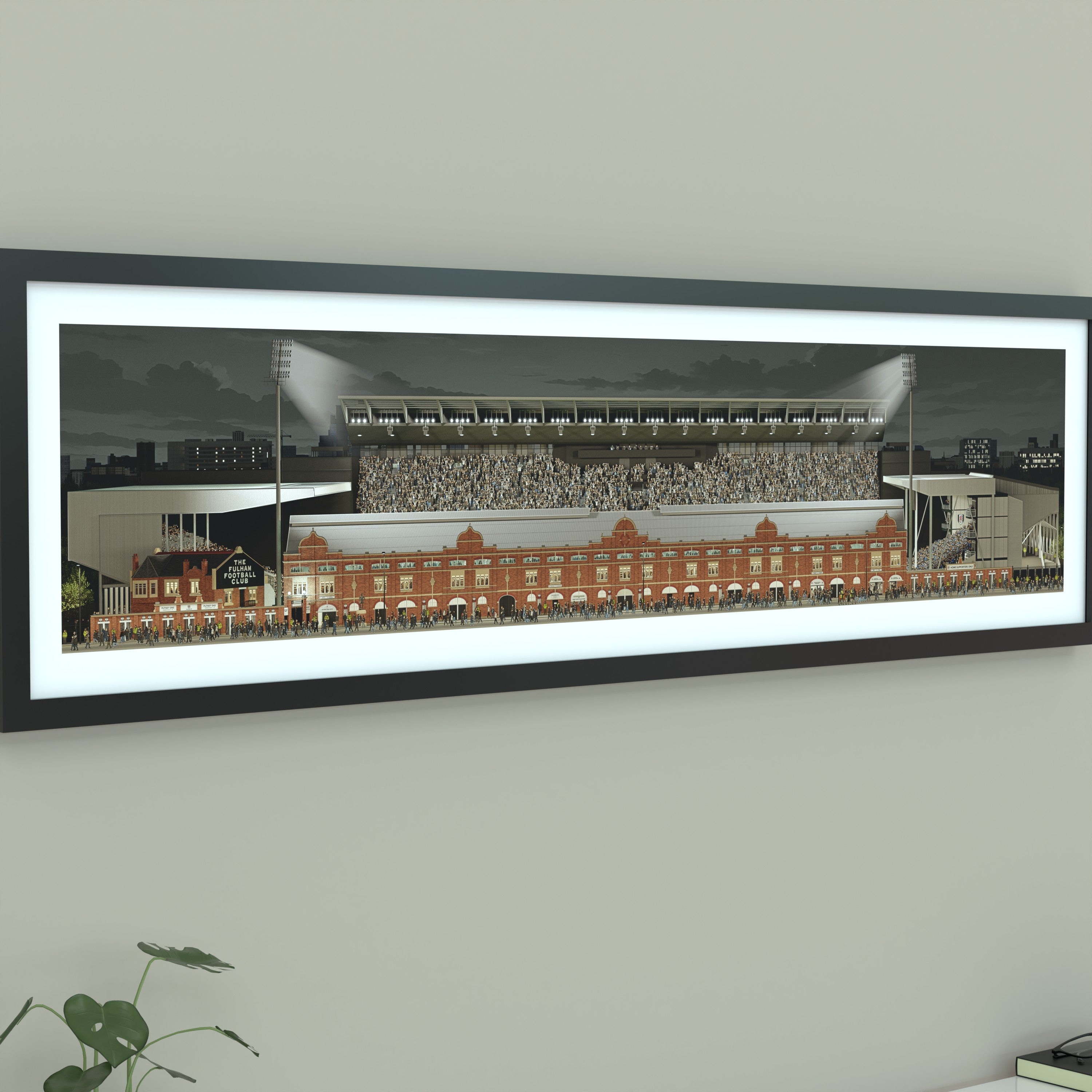 A framed panoramic print of a Fulham's Craven Cottage stadium, displayed on a light gray wall.