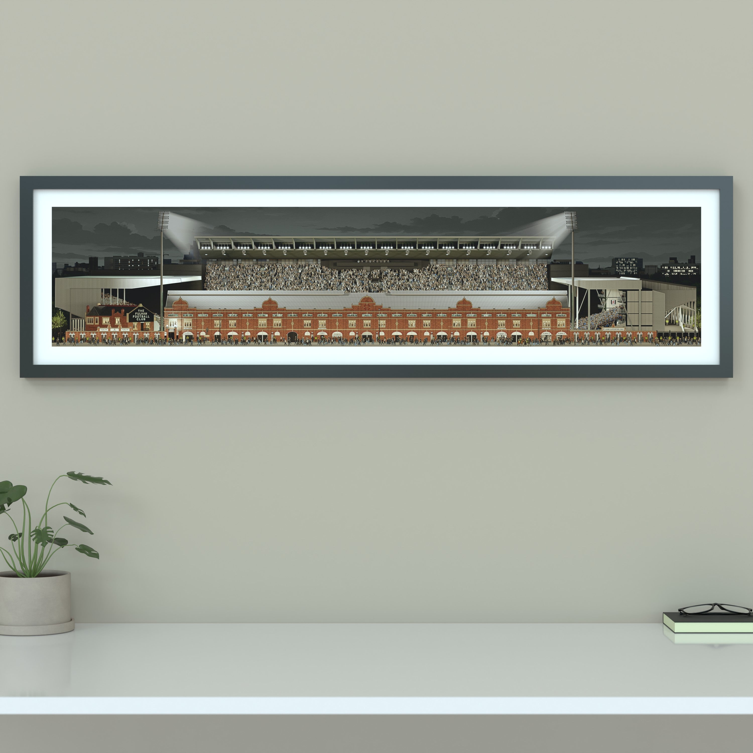 A framed panoramic print of a Fulham's Craven Cottage stadium, displayed on a light gray wall.