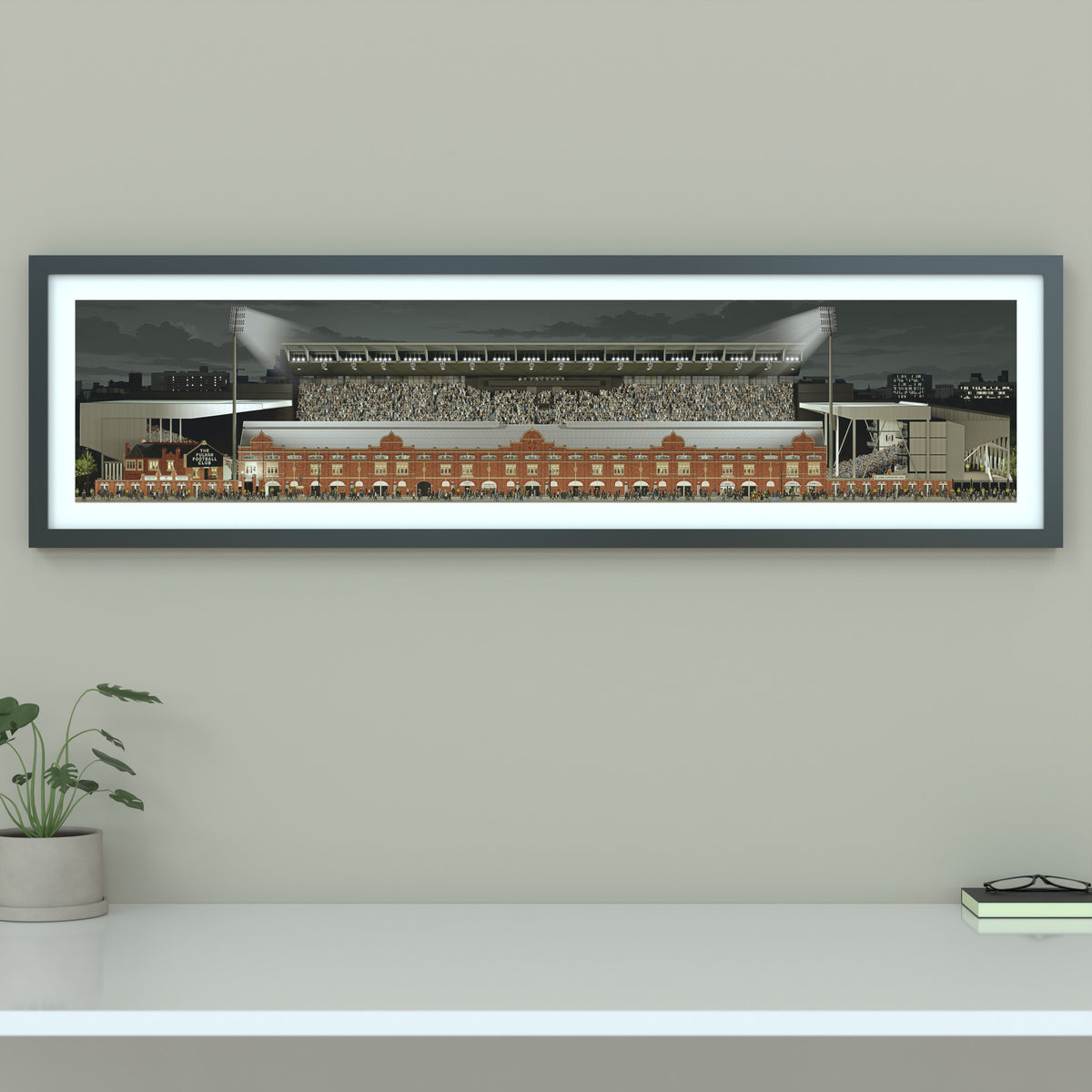 A framed panoramic print of a Fulham's Craven Cottage stadium, displayed on a light gray wall.