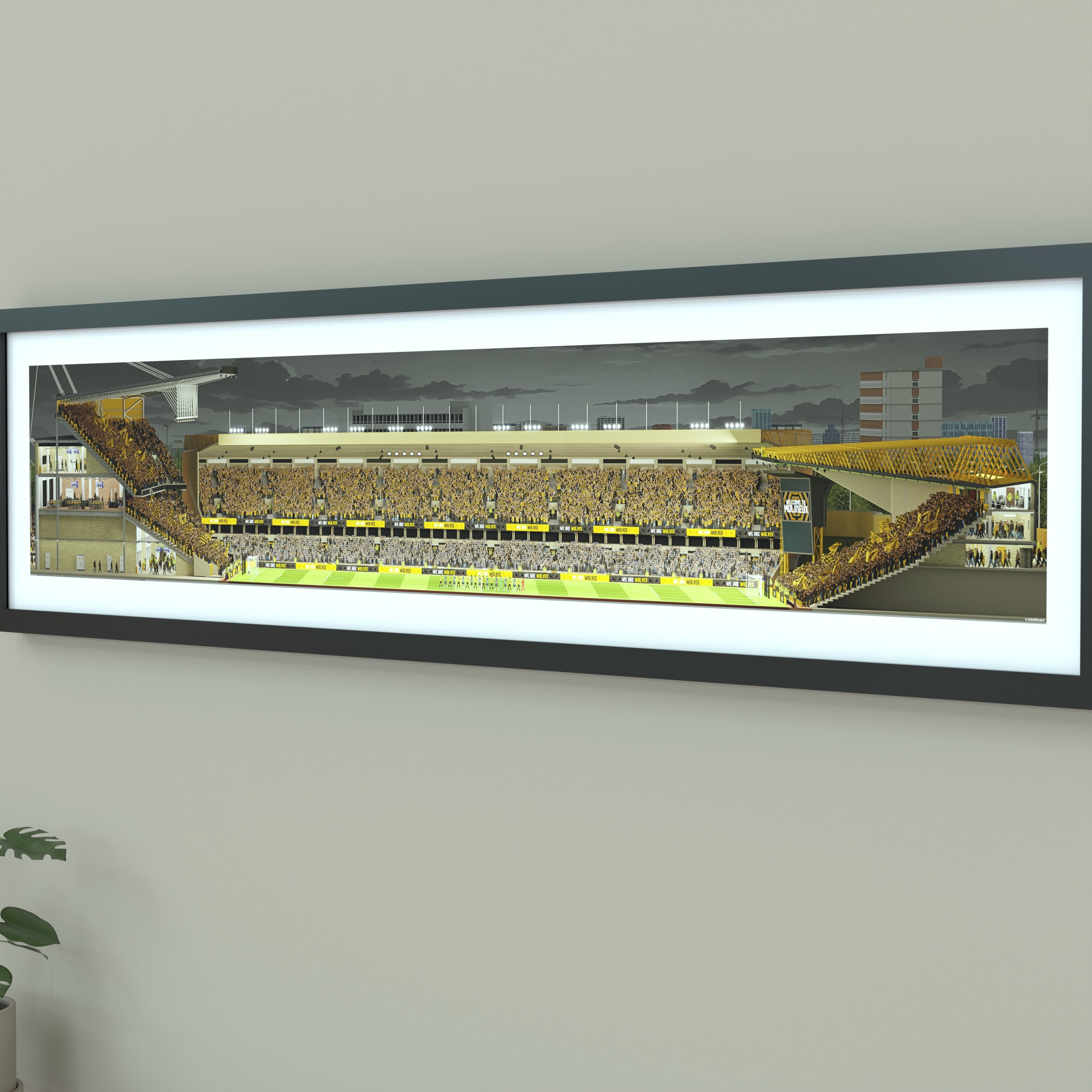 A framed panoramic art print of a Wolves' Molineux stadium, mounted on a light gray wall. The print features a detailed illustration of a stadium filled with yellow and black clad fans under a dark sky.