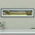 A framed panoramic art print of a Wolves' Molineux stadium, mounted on a light gray wall. The print features a detailed illustration of a stadium filled with yellow and black clad fans under a dark sky.
